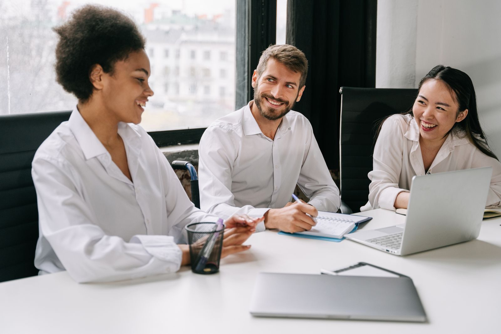 Lächelndes Team bei einer Besprechung im hellen Büro