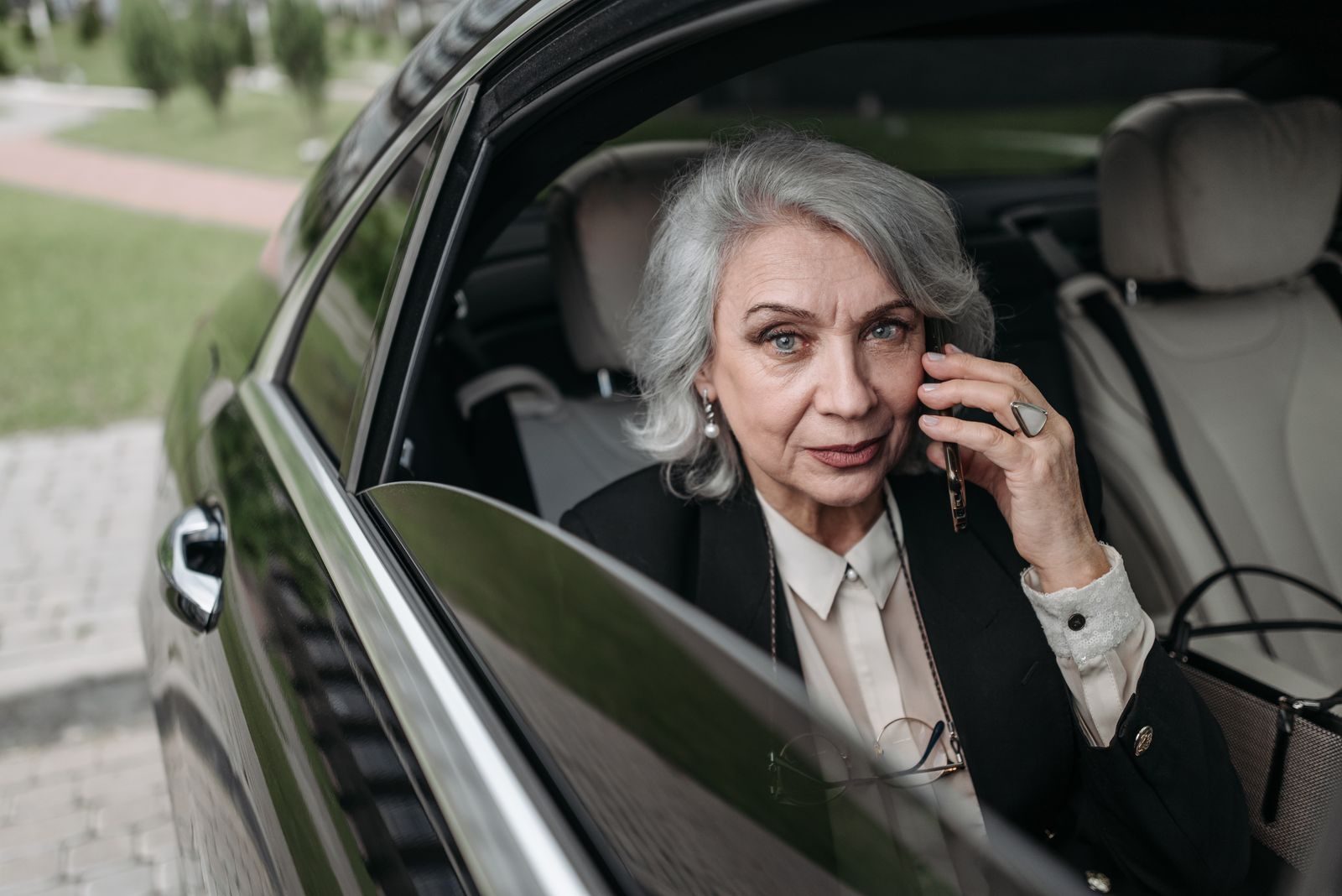 Chefin telefoniert im Auto zwischen zwei Terminen